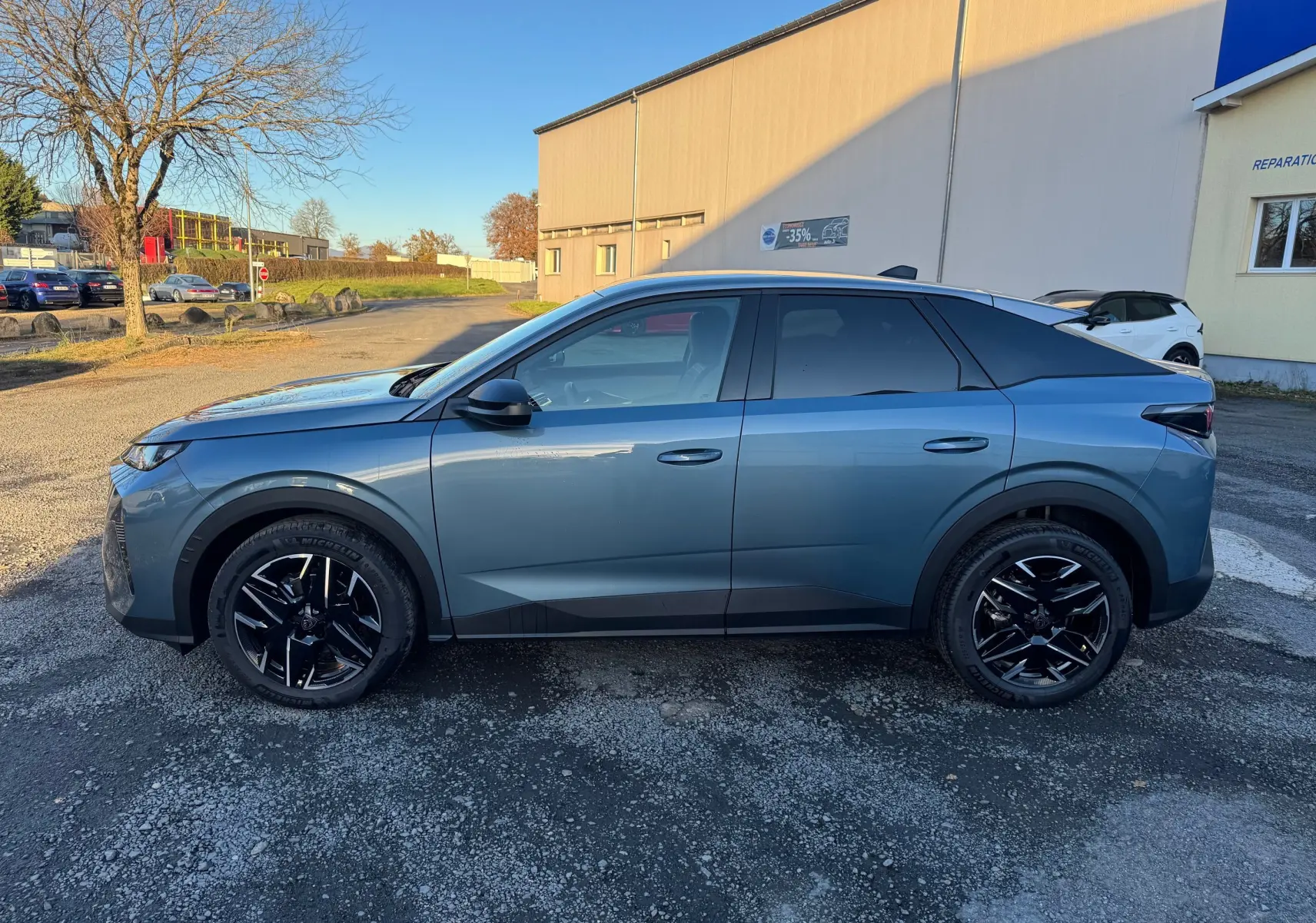 Peugeot 3008 Hybrid 136ch en bleu Nogaro, vue de profil côté gauche, avec jantes noires et toit noir contrasté.