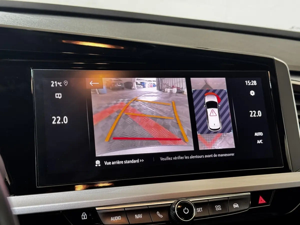 Écran tactile central de l’Opel Grandland gris clair montrant la caméra de recul et l’aide au stationnement.