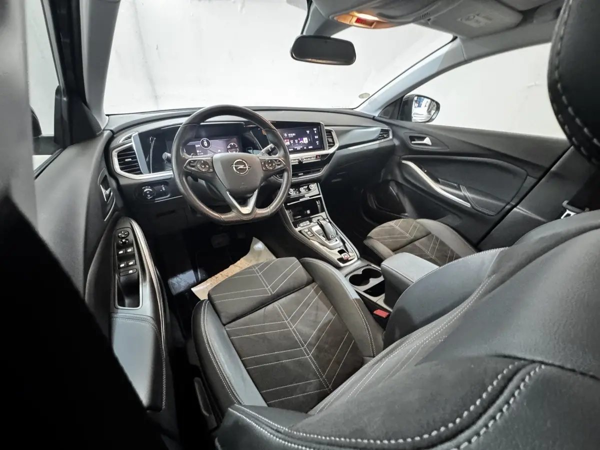 Intérieur de l’Opel Grandland 2022 vu côté conducteur, volant cuir, écran tactile et sièges tissu noir.