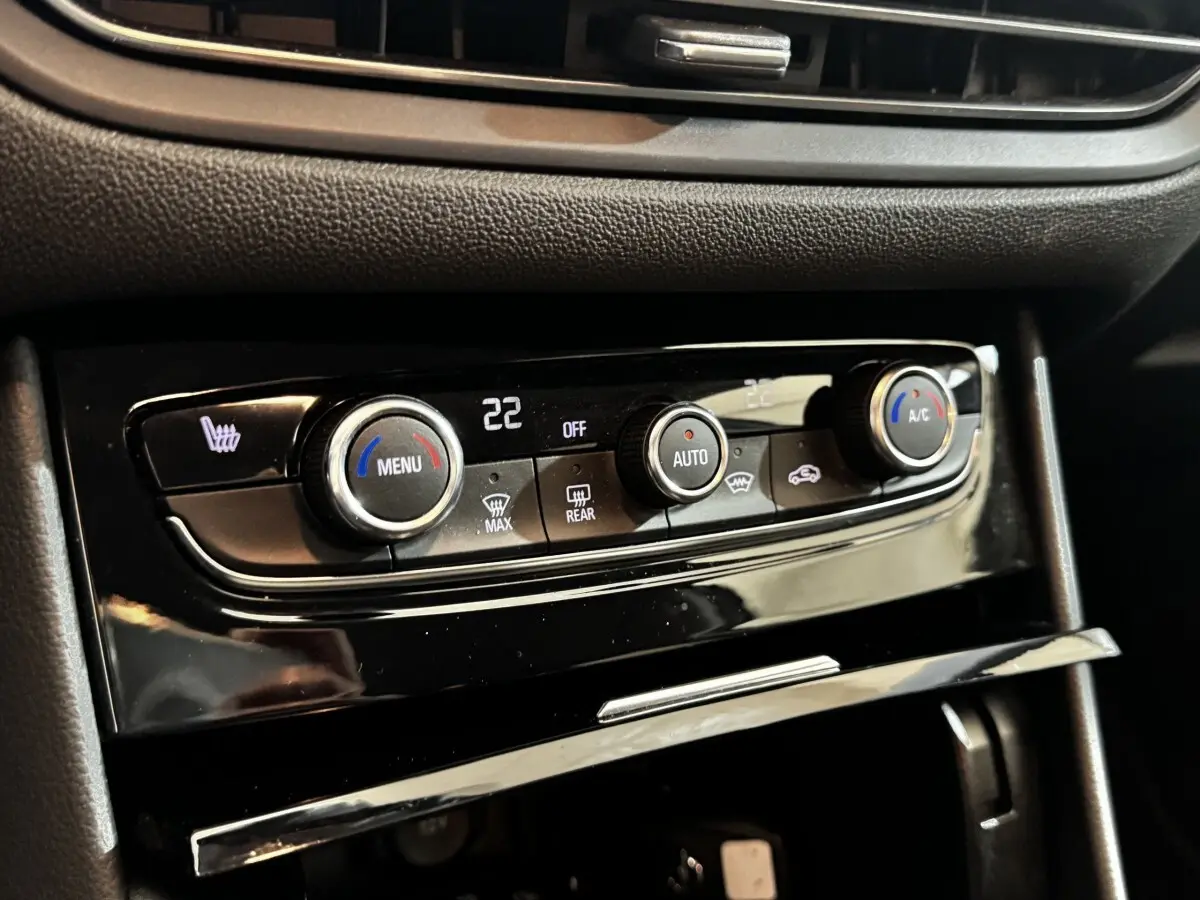 Gros plan sur la commande de la climatisation automatique bi-zone du tableau de bord noir d’un Opel Grandland gris clair.