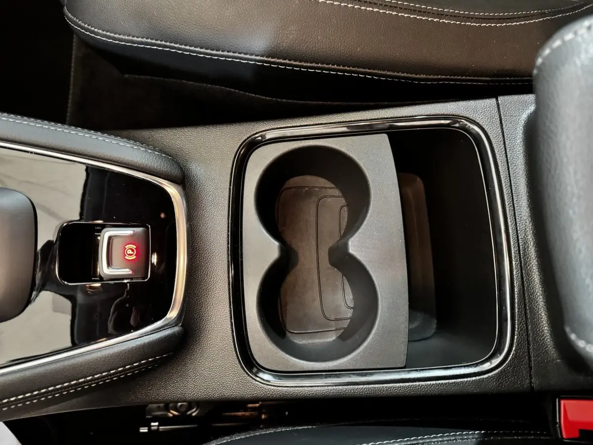 Gros plan intérieur sur la console centrale noire du Opel Grandland 2022 avec frein à main électrique et porte-gobelets.