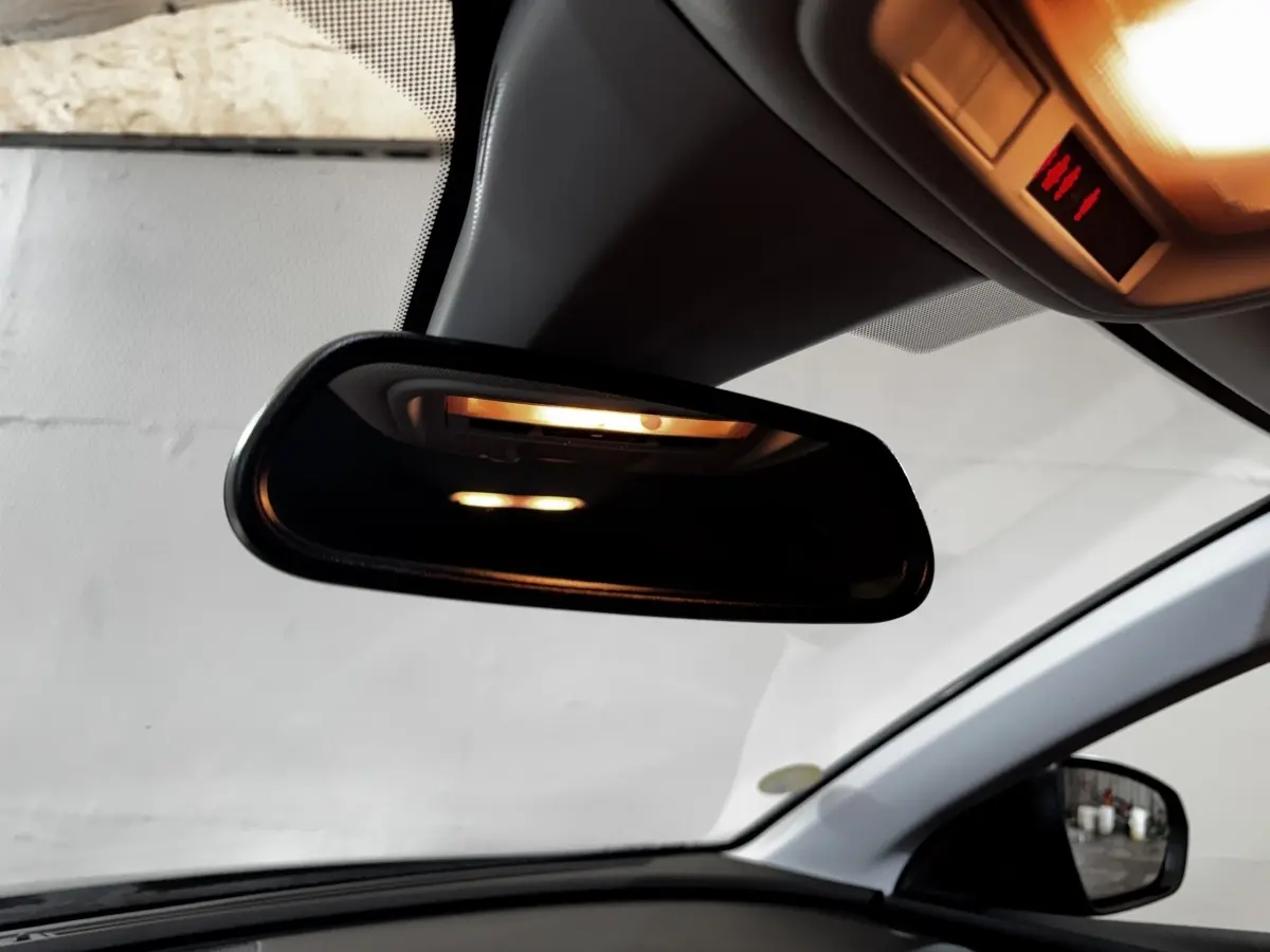 Vue intérieure centrée sur le rétroviseur intérieur et le plafond clair d’un Opel Grandland gris clair 2022.