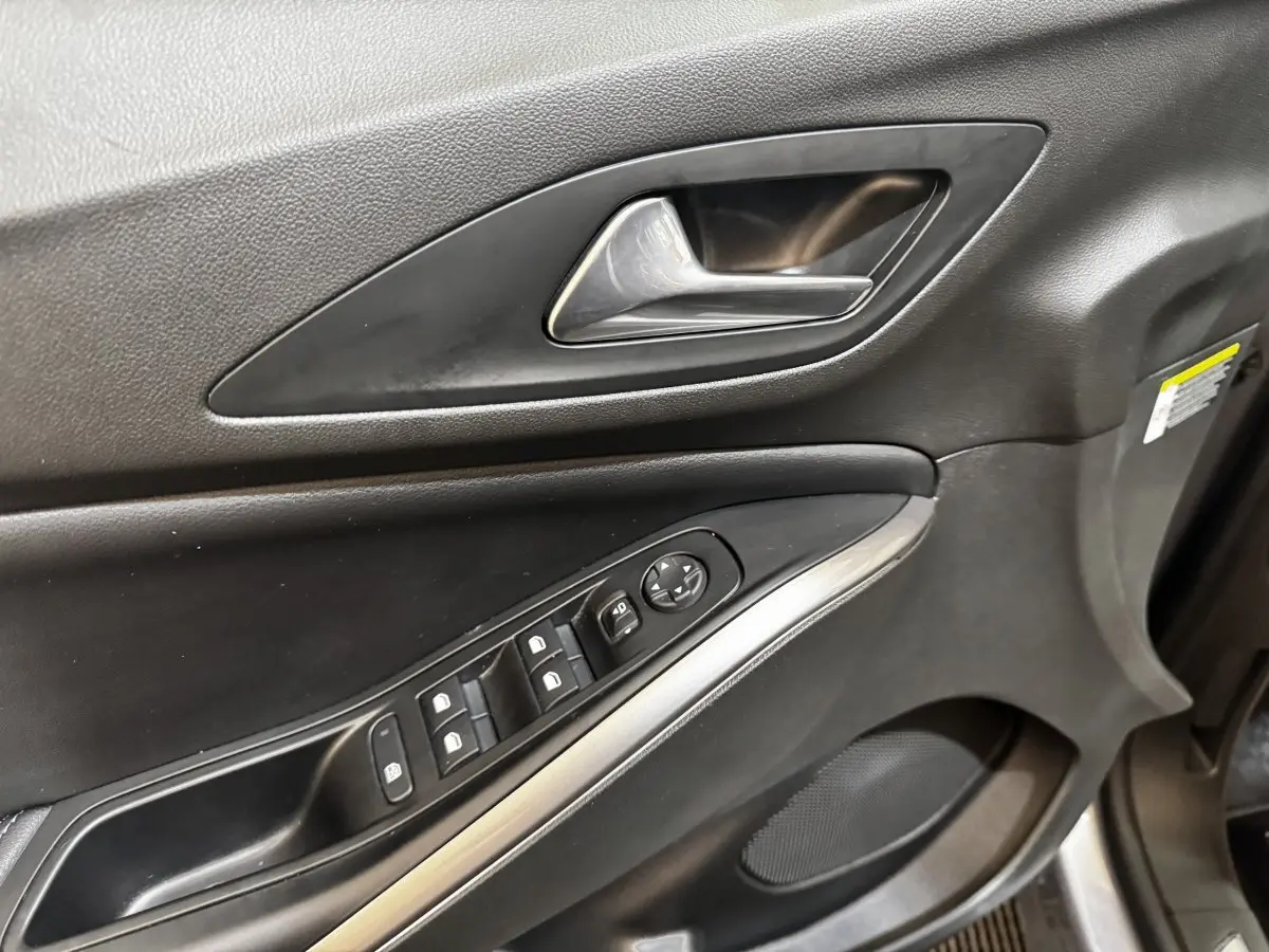 Gros plan sur la porte intérieure côté conducteur de l’Opel Grandland 2022, avec commandes de vitres et poignée argentée.