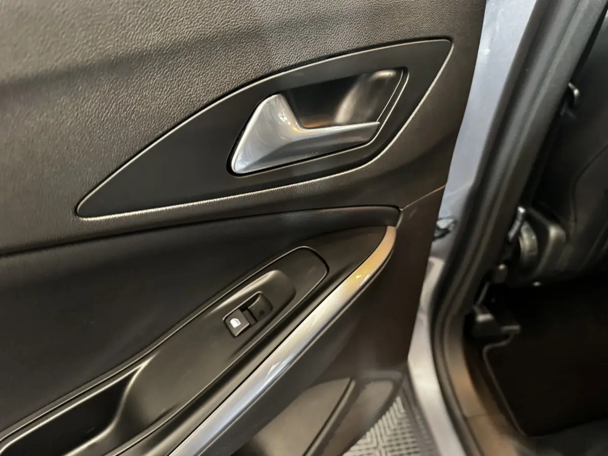 Gros plan sur la porte arrière droite intérieure gris clair de l'Opel Grandland avec poignée et commande de verrouillage.