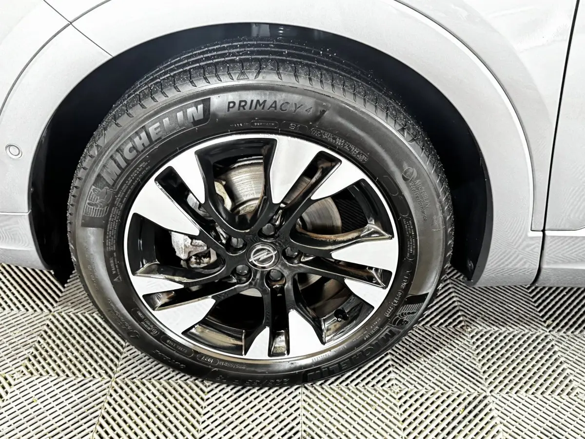 Gros plan sur la roue avant gauche gris clair d’un Opel Grandland 2022 avec jante alliage bicolore et pneu Michelin.