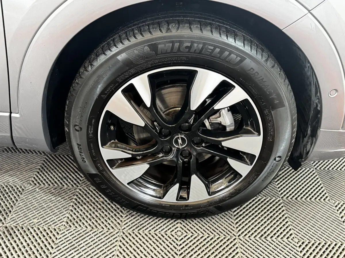 Gros plan sur la roue avant droite gris clair d’un Opel Grandland 2022 avec jante alliage noir et argent.