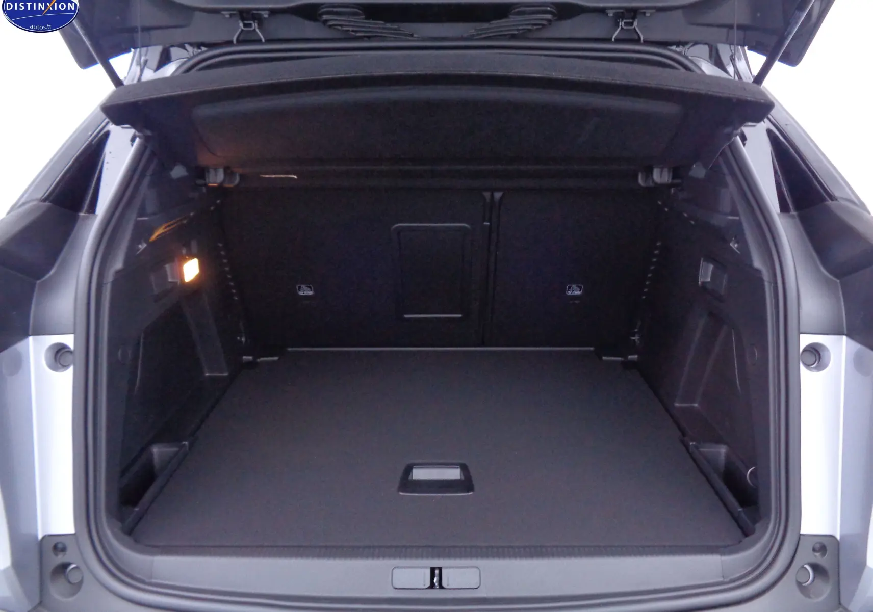Coffre ouvert d'un Peugeot 3008 gris Artense métal, vue arrière montrant un espace de chargement spacieux et bien éclairé.