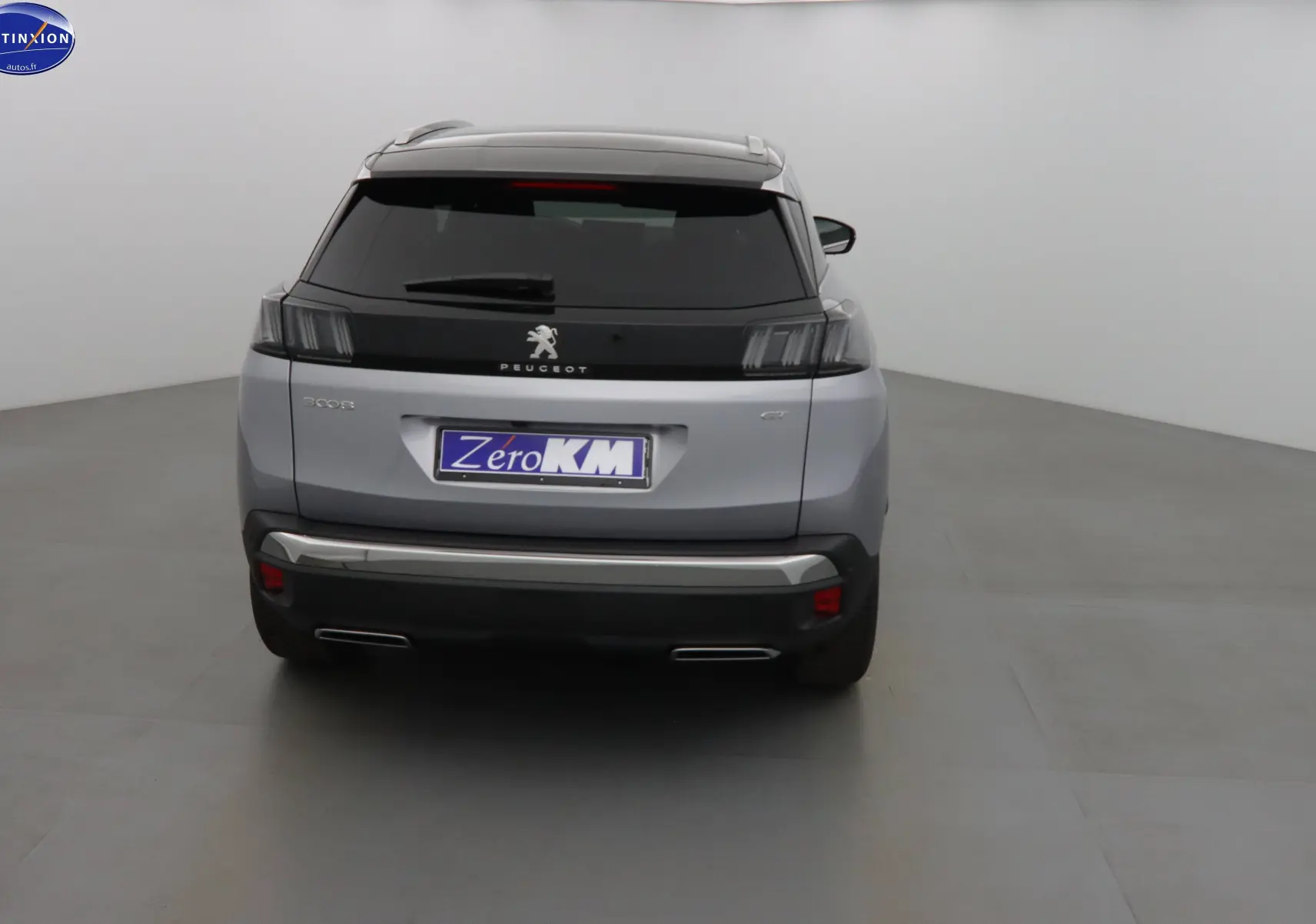 Vue arrière d’un Peugeot 3008 gris Artense 2023 avec feux arrière noirs et double sortie d’échappement chromée.
