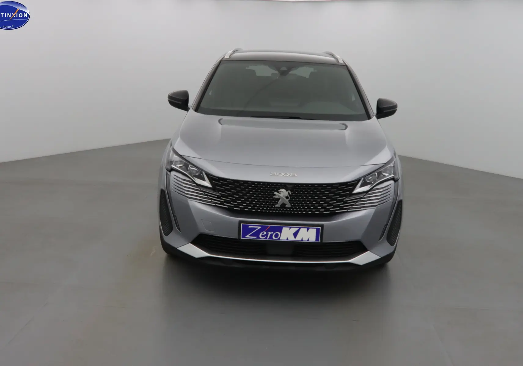 Vue frontale d'un Peugeot 3008 gris Artense métal avec calandre noire et logo lion central bien visible.