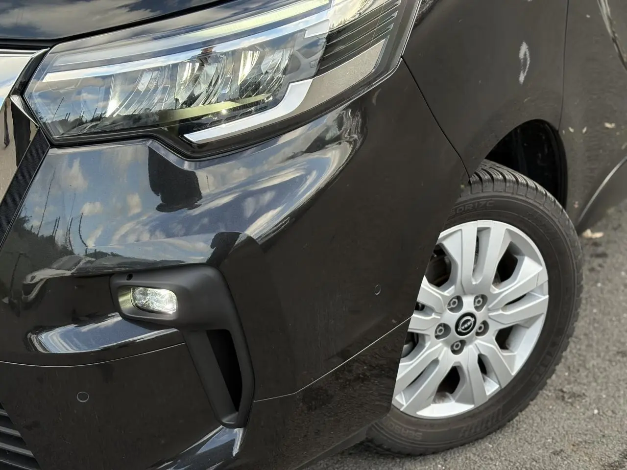 Gros plan sur l'avant droit noir métallisé du Nissan Primastar Combi 2025 avec phare LED et jante alliage 17 pouces.