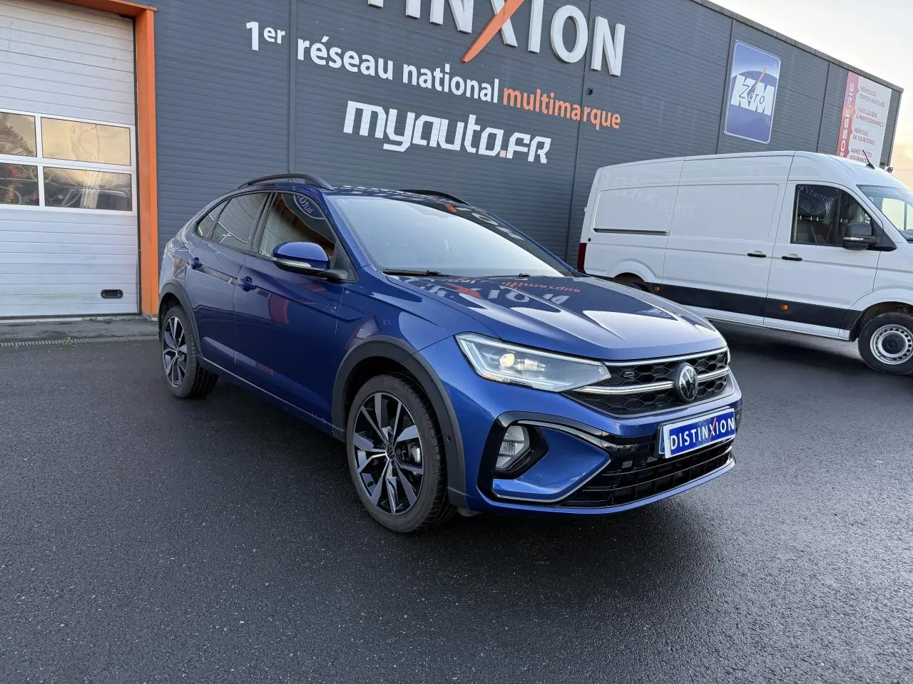 Volkswagen Taigo R-Line bleu récif métallisé en 3/4 avant droit avec jantes noires brillantes et calandre marquée R-Line.