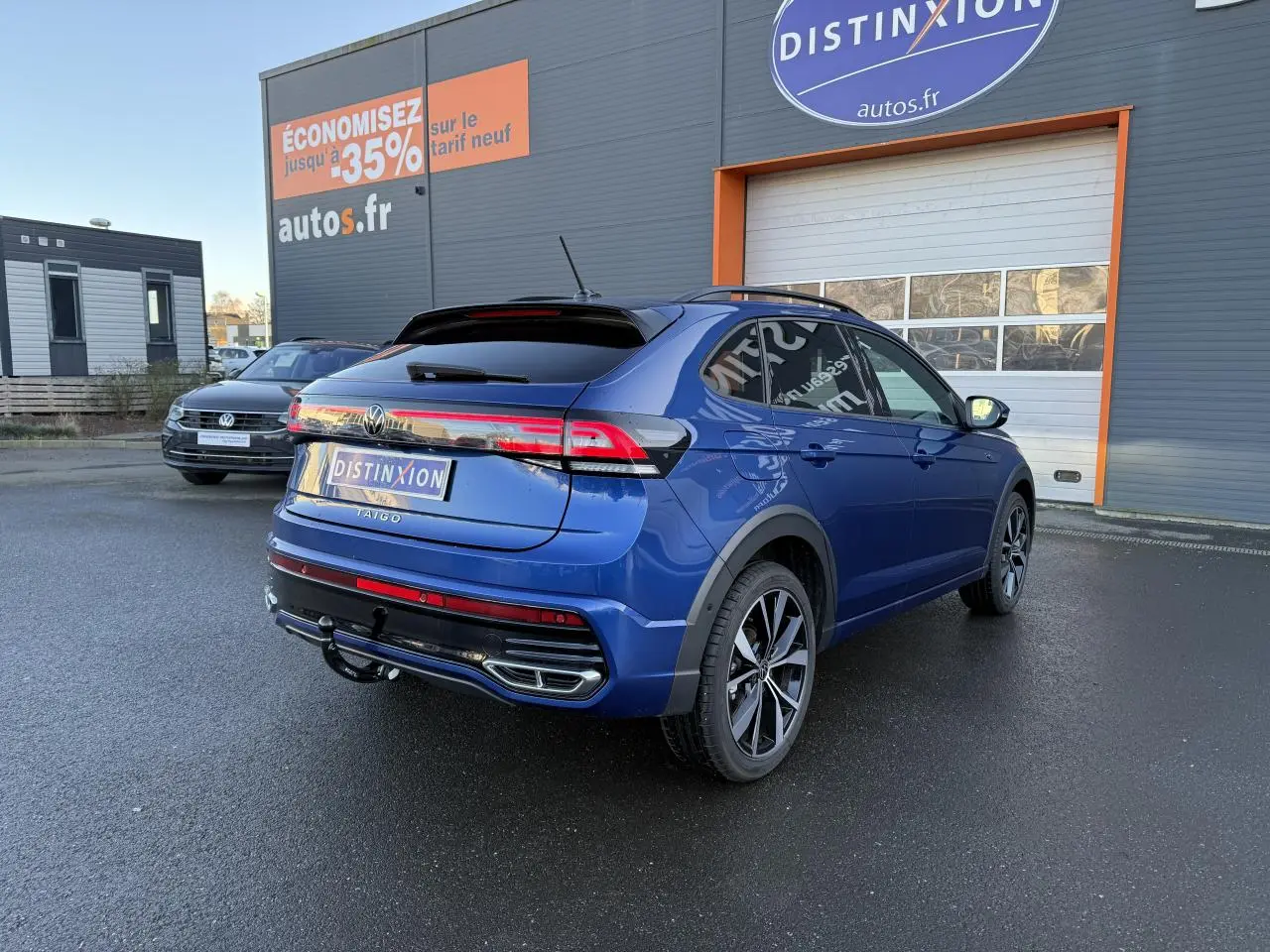 Volkswagen Taigo bleu récif métallisé en 3/4 arrière droit avec jantes noires brillantes et attelage amovible