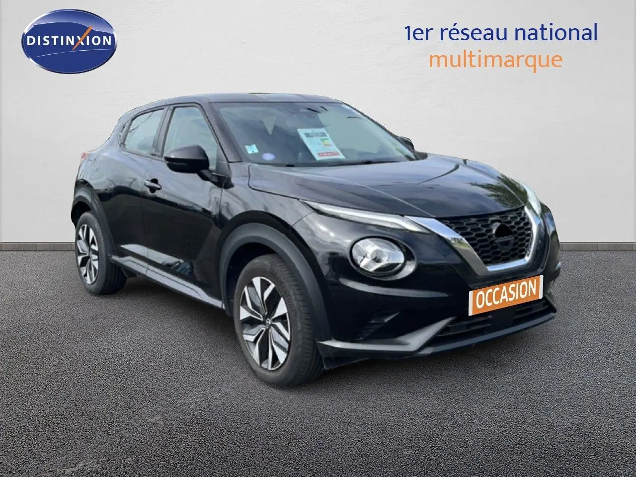Nissan Juke noir métal en 3/4 avant droit, avec calandre V-Motion et jantes alliage distinctives.