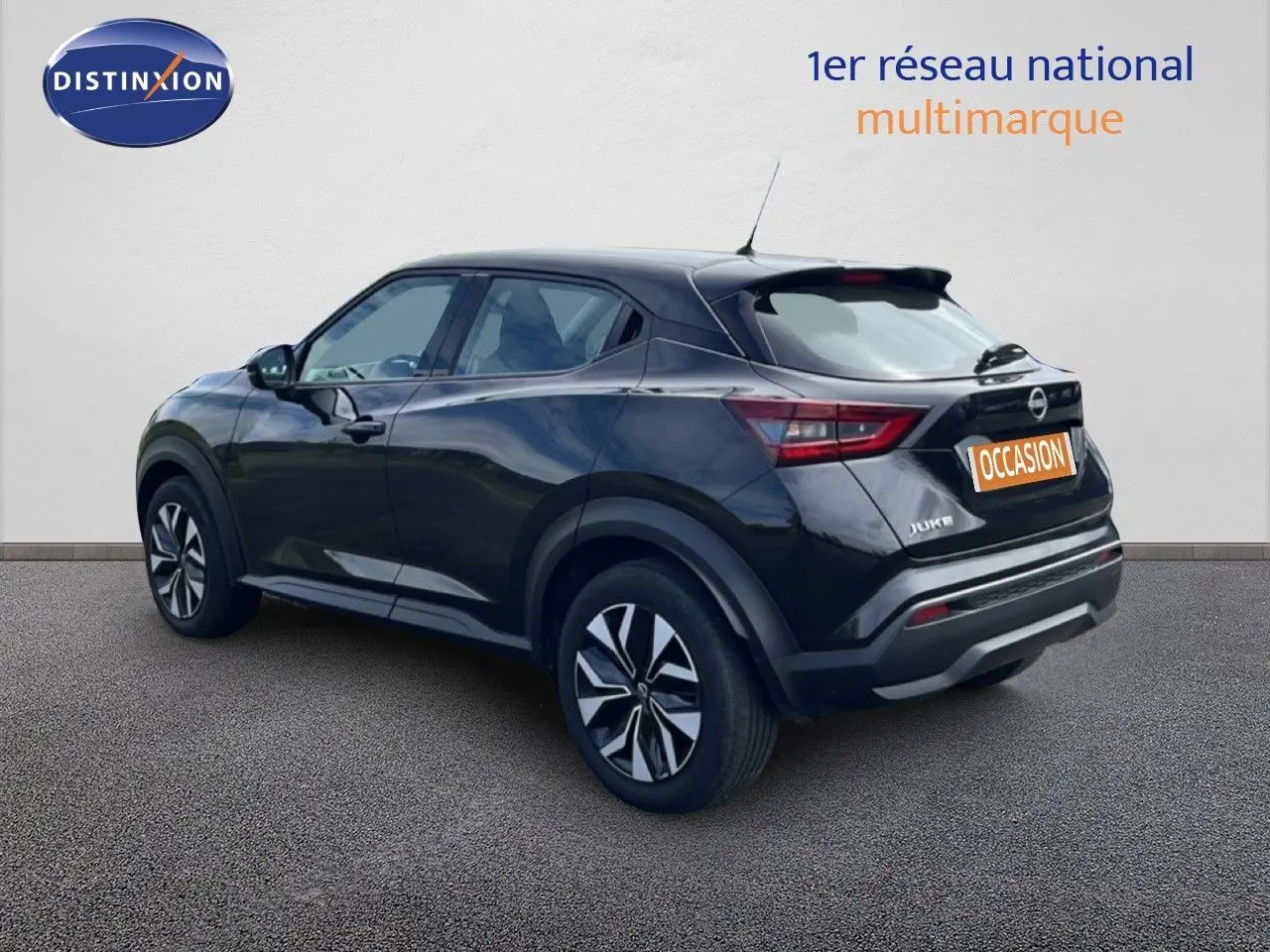 Nissan Juke noir métal en 3/4 arrière droit, avec jantes distinctives et feux arrière LED visibles.