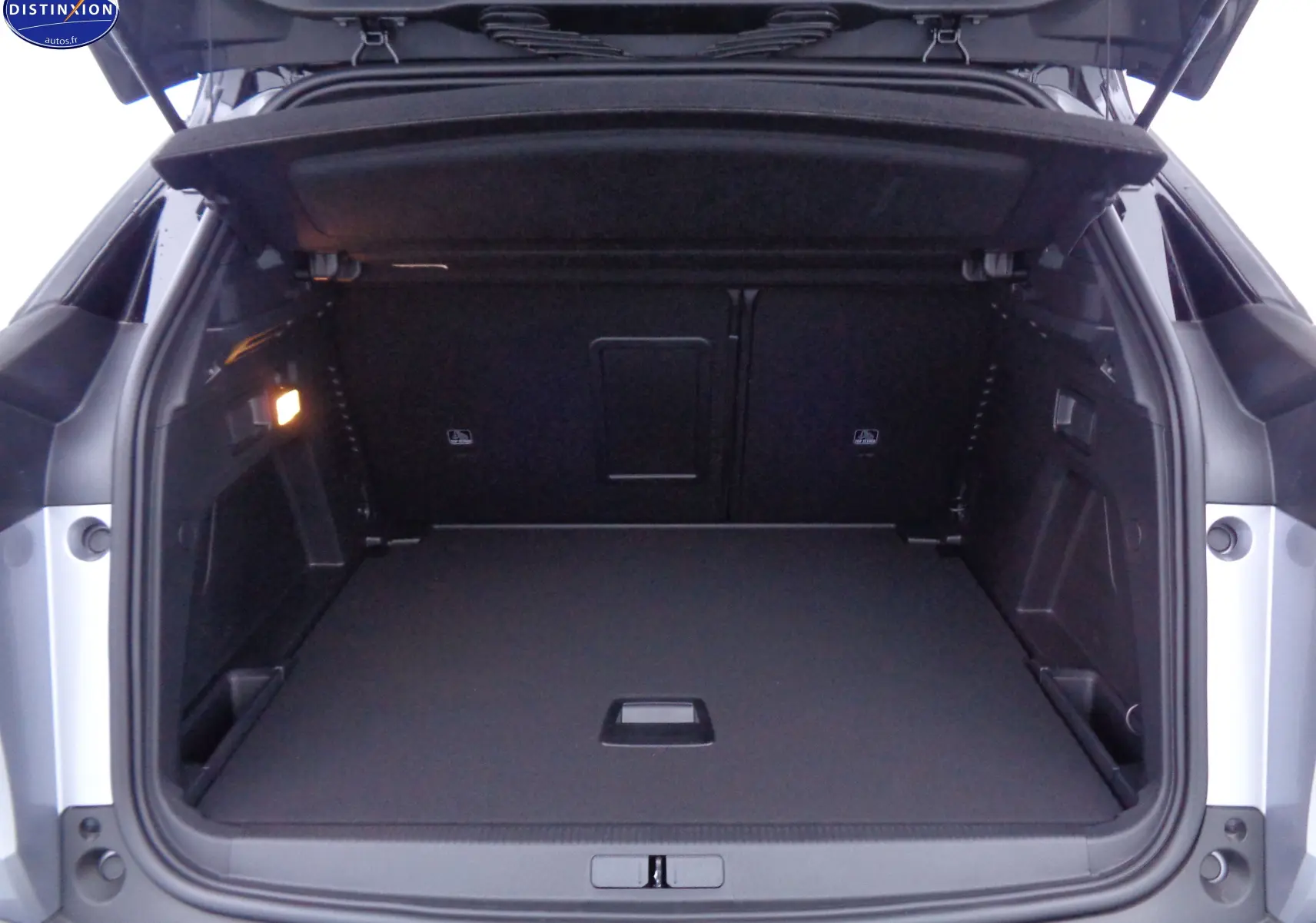 Coffre ouvert du Peugeot 3008 gris Artense Metal 2023, vue arrière montrant un espace de chargement spacieux et propre.