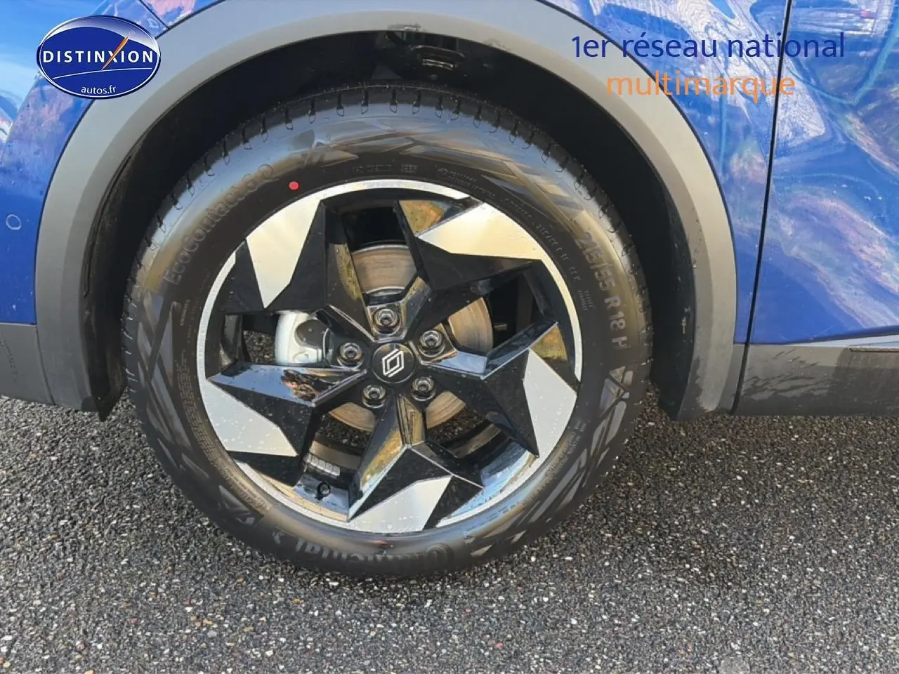 Gros plan sur la roue avant gauche du Renault Captur bleu iron avec jante alu à design étoilé.