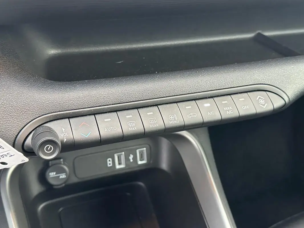 Vue rapprochée de la console centrale noire du Jeep Avenger 2025, montrant les commandes climatisation et ports USB.