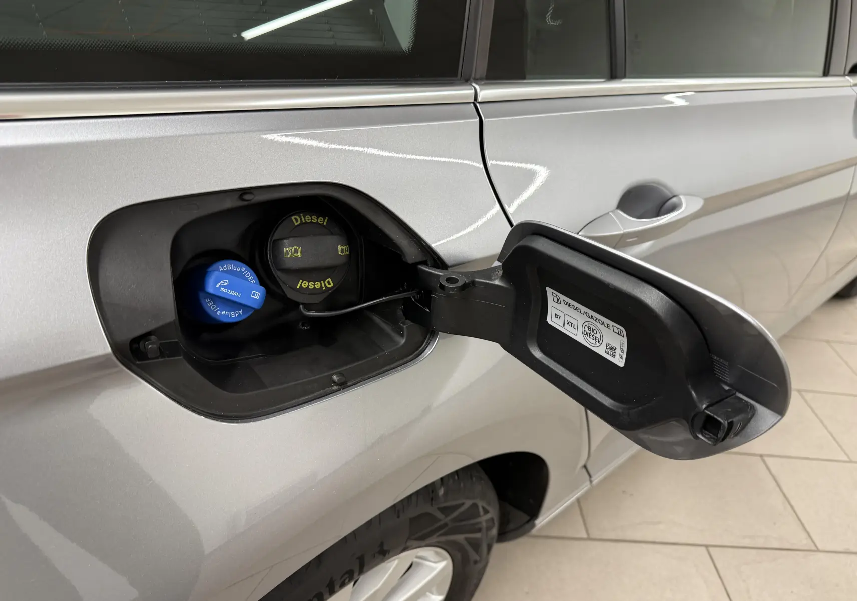 Vue rapprochée de la trappe à carburant ouverte côté gauche d'une Volkswagen Passat SW 2.0 TDI gris pyrite 2024.