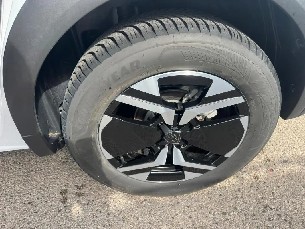 Gros plan sur la jante alliage noire et argent de 17 pouces du Peugeot 2008 blanc, avec pneu Goodyear visible.