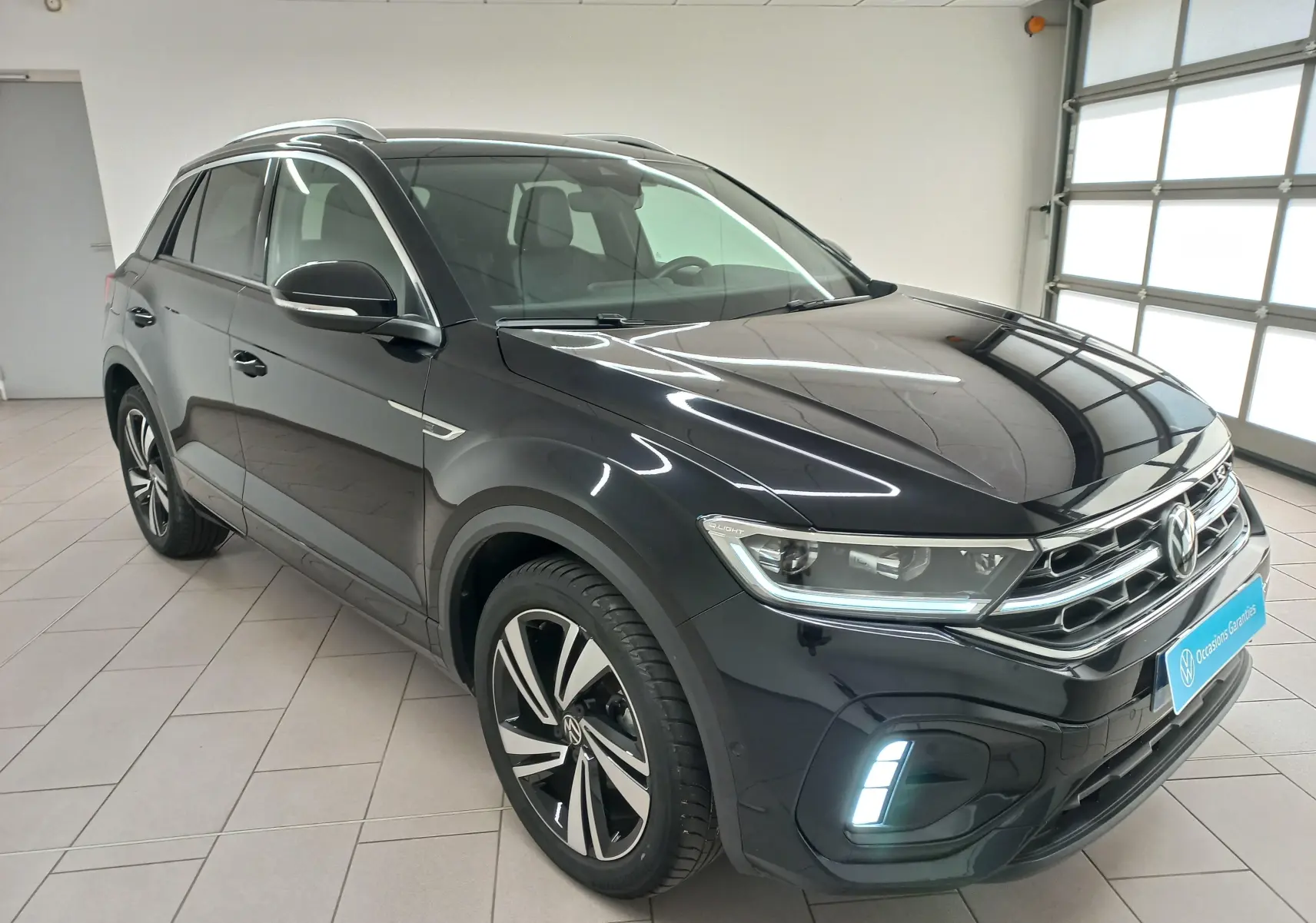 Volkswagen T-Roc 2025 noir intense nacré, vue 3/4 avant droit, avec phares Matrix LED et jantes R-Line.