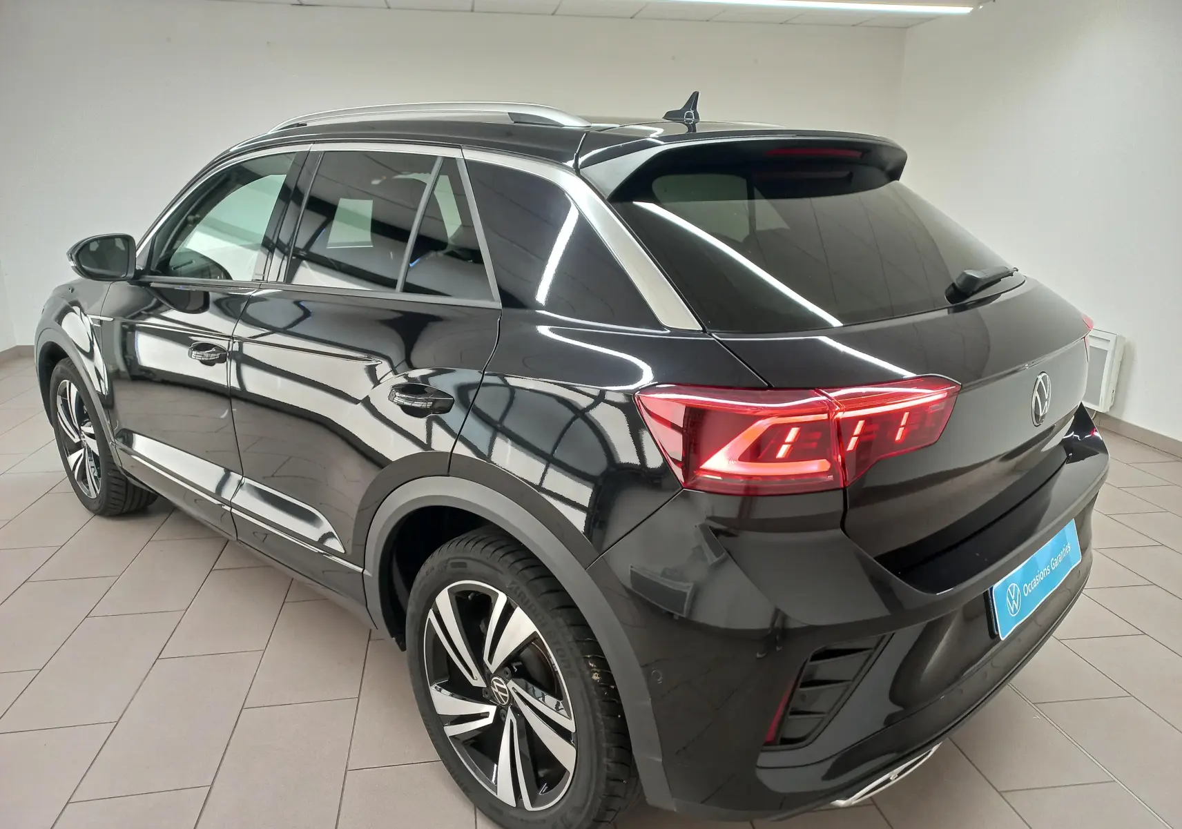 Vue 3/4 arrière droite du Volkswagen T-Roc 1.5 TSI R-Line noir intense nacré avec feux LED et jantes alliage.