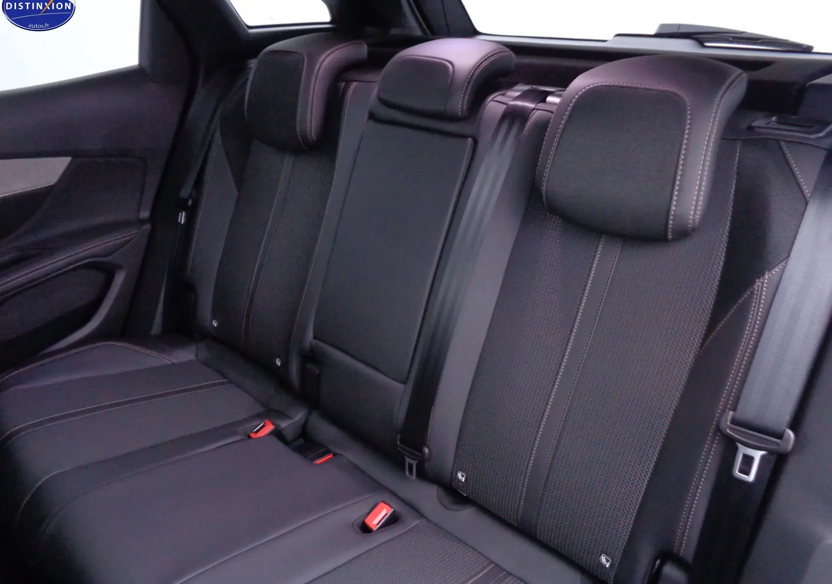 Vue intérieure arrière des sièges noirs en cuir et tissu du Peugeot 3008 GT 2023, soulignant les appuie-têtes et ceintures de sécurité.