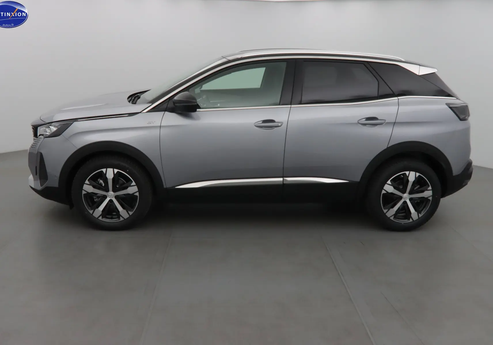 Profil côté gauche du Peugeot 3008 gris Artense métal 2023 avec jantes alliage bicolores et vitres teintées.