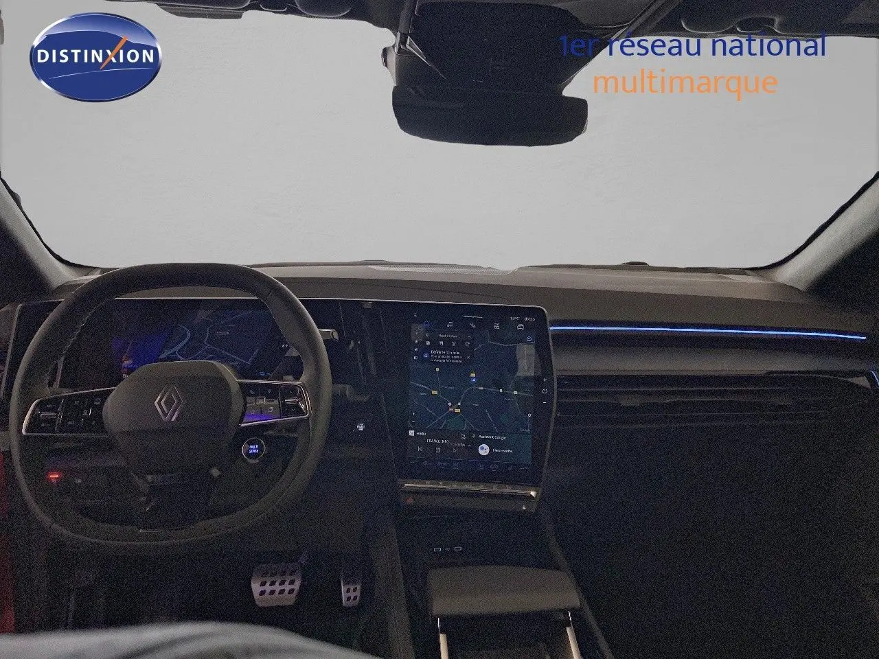 Vue intérieure du tableau de bord et volant de la Renault Rafale rouge flamme, avec écran tactile central et éclairage d'ambiance bleu.