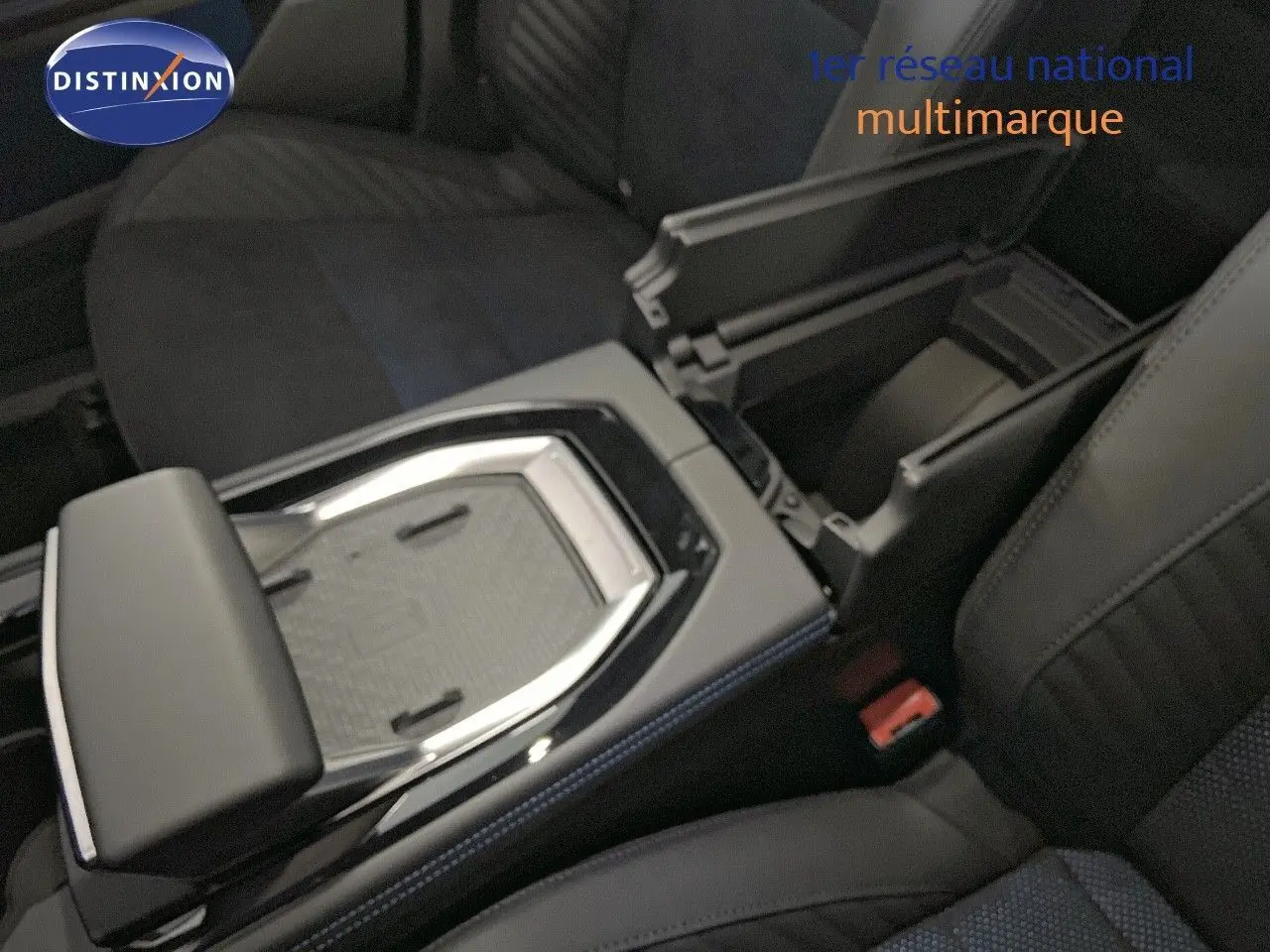 Vue rapprochée de la console centrale avec accoudoir ouvert et sièges en cuir noir et tissu bleu du Renault Rafale 2024.