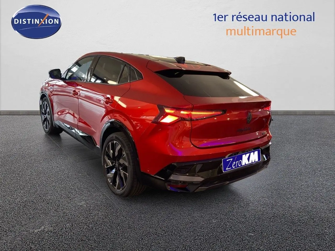 Vue 3/4 arrière droite d'un Renault Rafale rouge flamme métal 2024 avec feux arrière allumés et jantes noires.