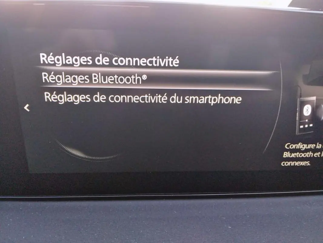 Écran central du tableau de bord du Mazda MX-30 gris 2021 montrant les réglages de connectivité Bluetooth.