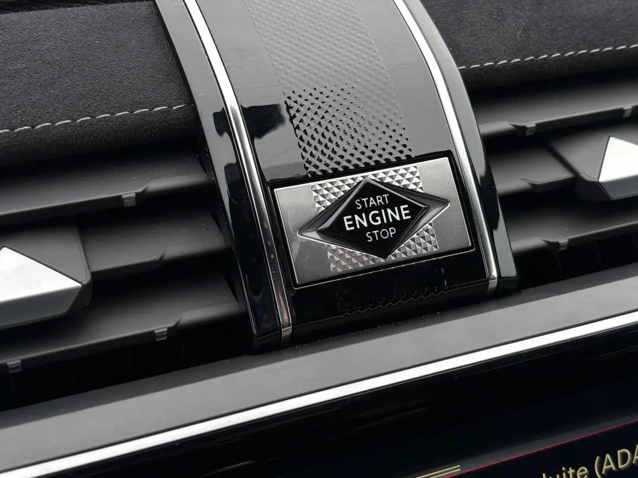 Détail du bouton Start Engine Stop sur la console centrale noire brillante du DS7 gris laqué 2024.