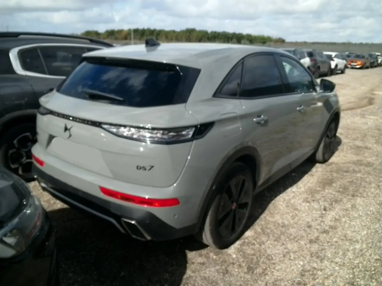 DS7 gris laqué vu en 3/4 arrière droit, avec feux arrière LED 3D et jantes alliage noires 19 pouces.