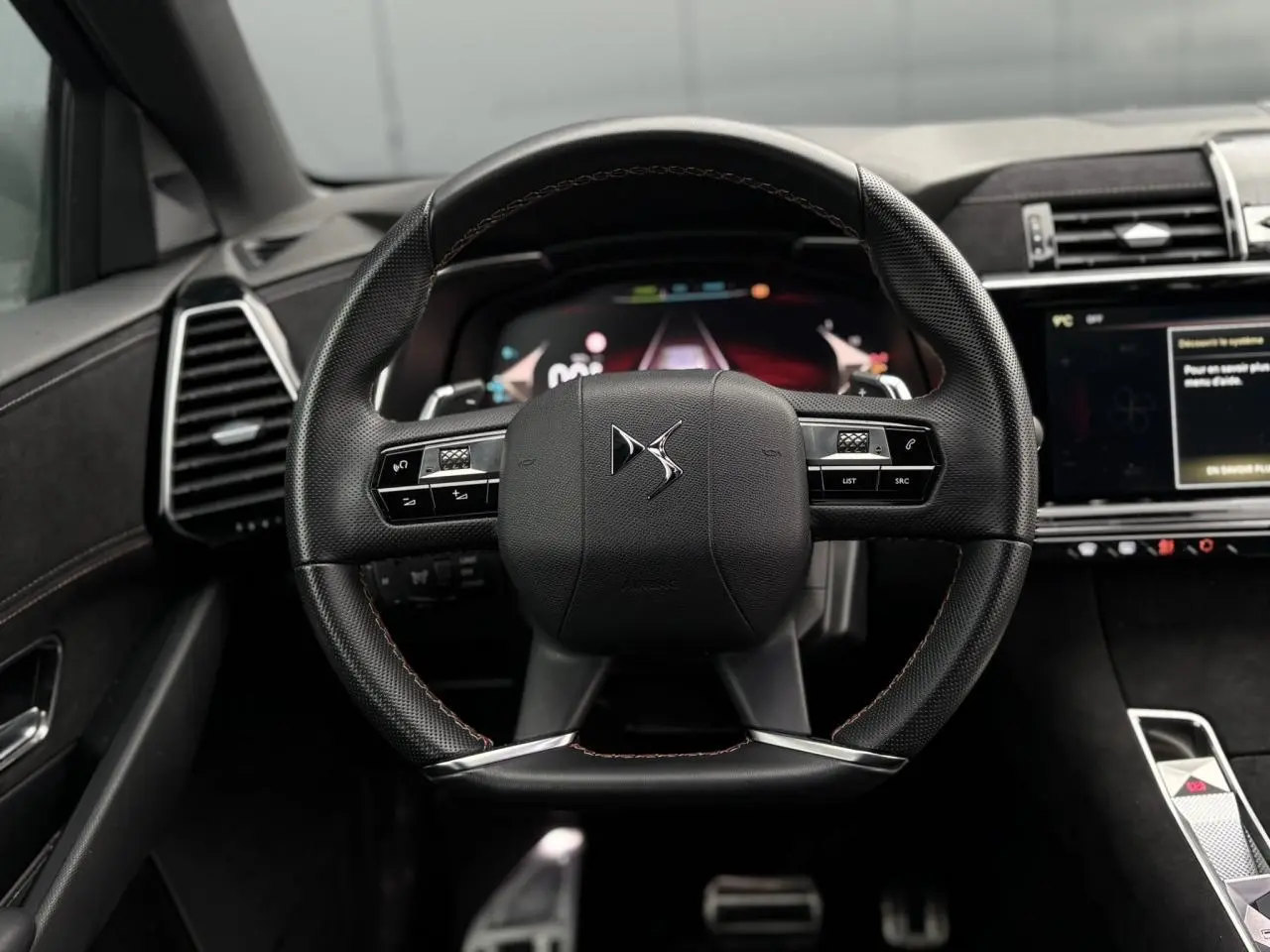 Volant en cuir noir perforé avec coutures or et carmin du DS7 1.6 E-Tense 2024, vue frontale intérieure centrée.