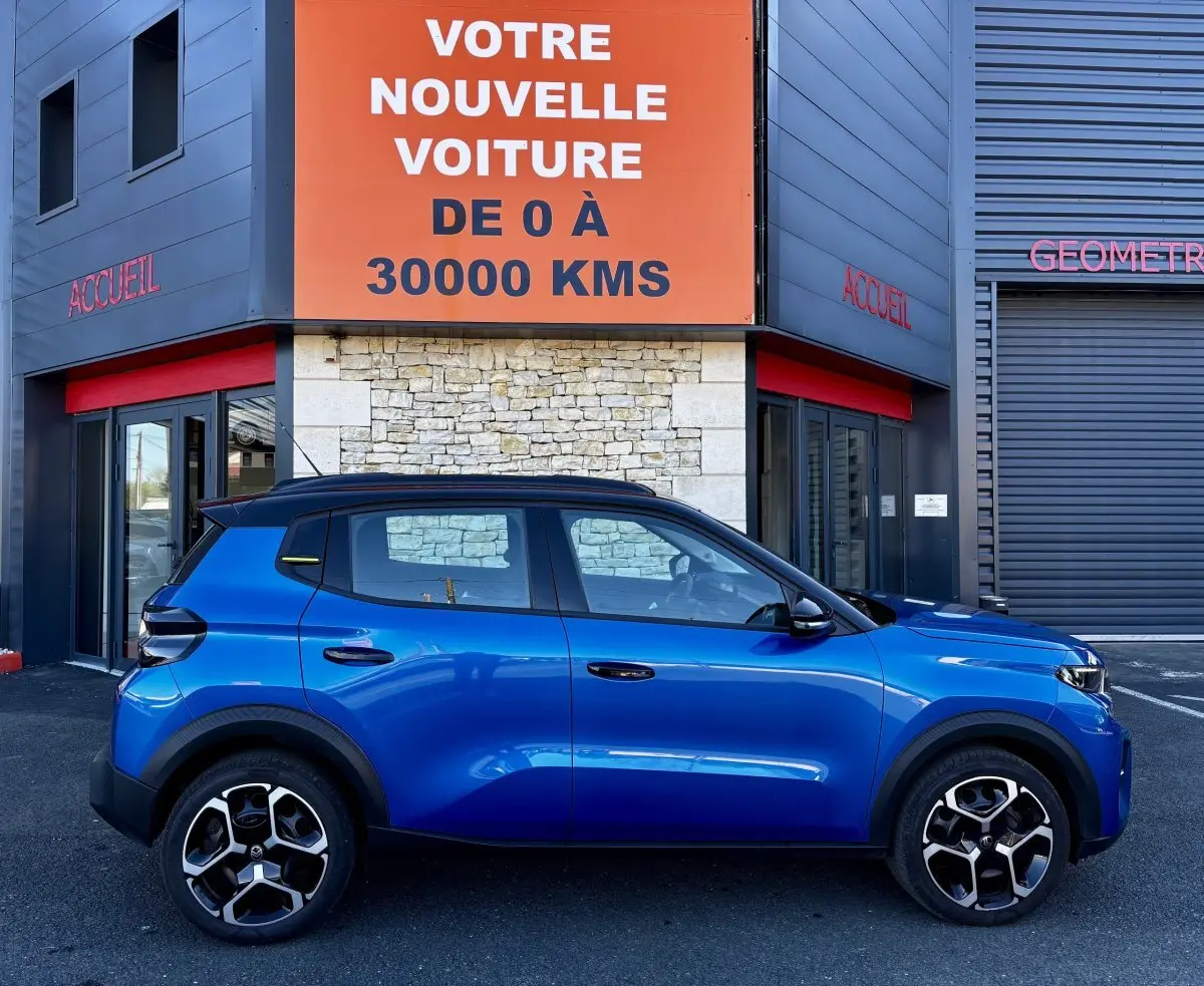 Profil côté gauche de la Citroën C3 100 BVM PLUS bleu 2025 avec toit noir et jantes au design moderne.