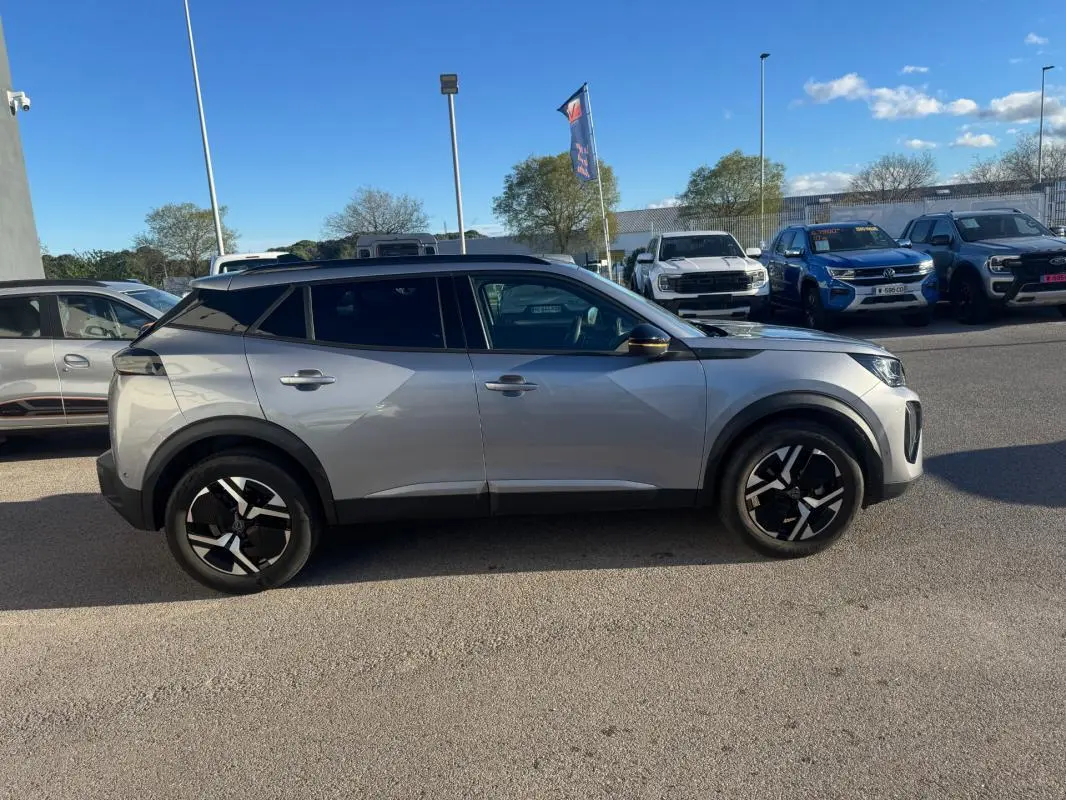 Peugeot 2008 Hybrid gris vue de profil côté gauche, avec jantes alliage 17 pouces et barres de toit noires.