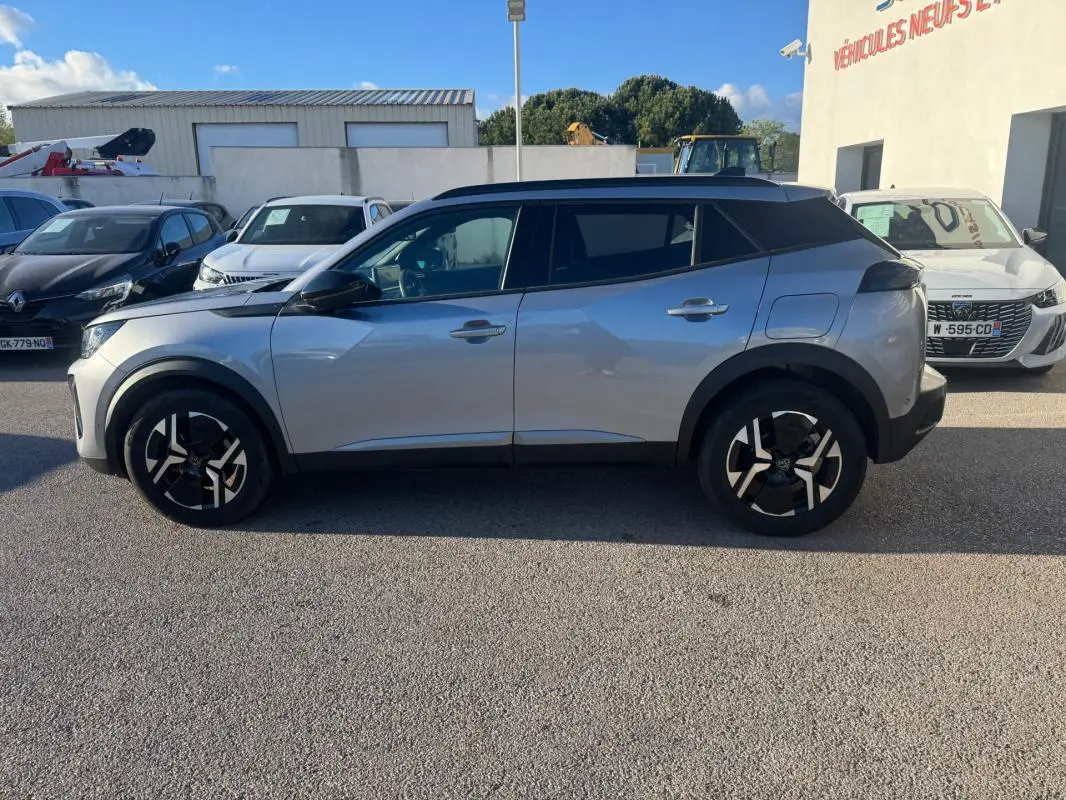 Peugeot 2008 Hybrid gris vue de profil côté gauche, avec jantes alliage 17 pouces et barres de toit noires.