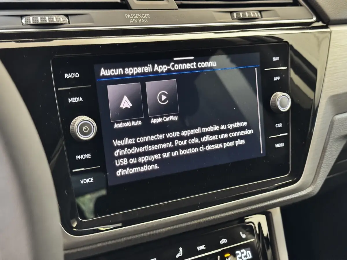 Vue rapprochée de l’écran tactile central et des commandes noires du tableau de bord intérieur du Volkswagen Touran 2024.