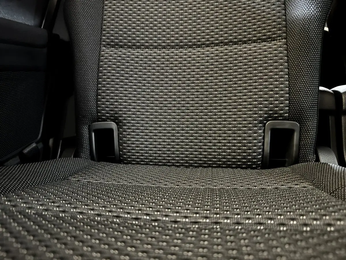 Gros plan sur le tissu gris texturé d’un siège arrière du Volkswagen Touran 2024, version 7 places.