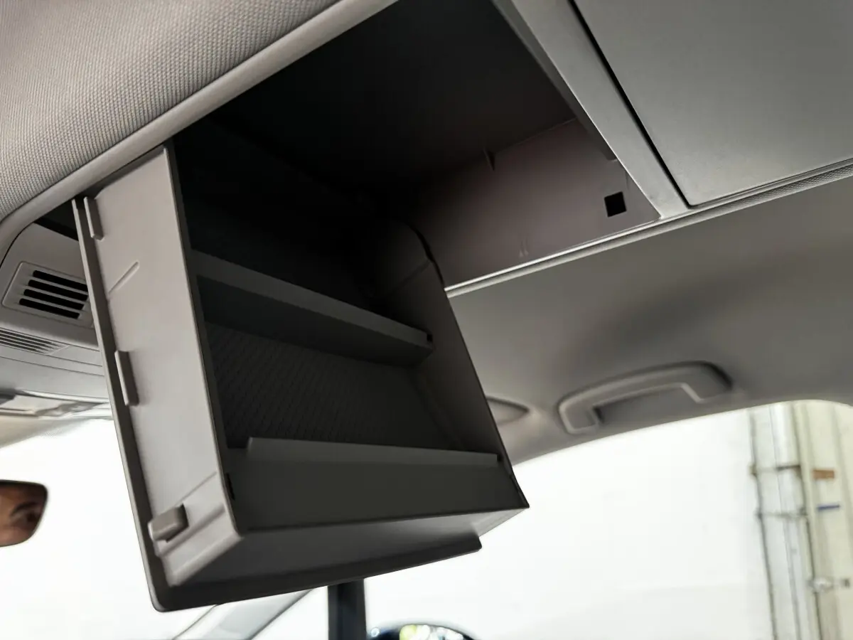 Rangement réfrigéré ouvert sous le plafond intérieur du Volkswagen Touran 2024, vue en contre-plongée.