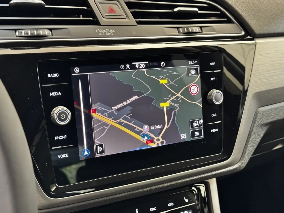 Écran tactile central du Volkswagen Touran 2024 affichant la navigation avec carte et commandes autour en intérieur gris.
