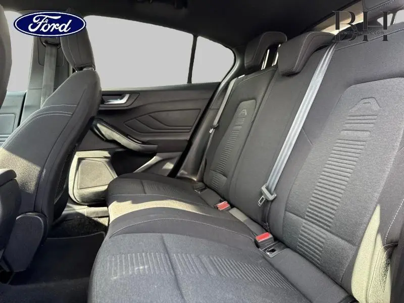 Vue latérale intérieure montrant la banquette arrière noire de la Ford Focus 1.0 EcoBoost 2020 avec ceintures et appuie-têtes.