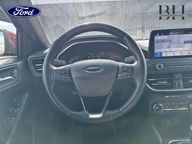 Vue intérieure centrée sur le volant cuir multifonction d'une Ford Focus 1.0 EcoBoost 2020 avec écran tactile et commandes au tableau de bord.