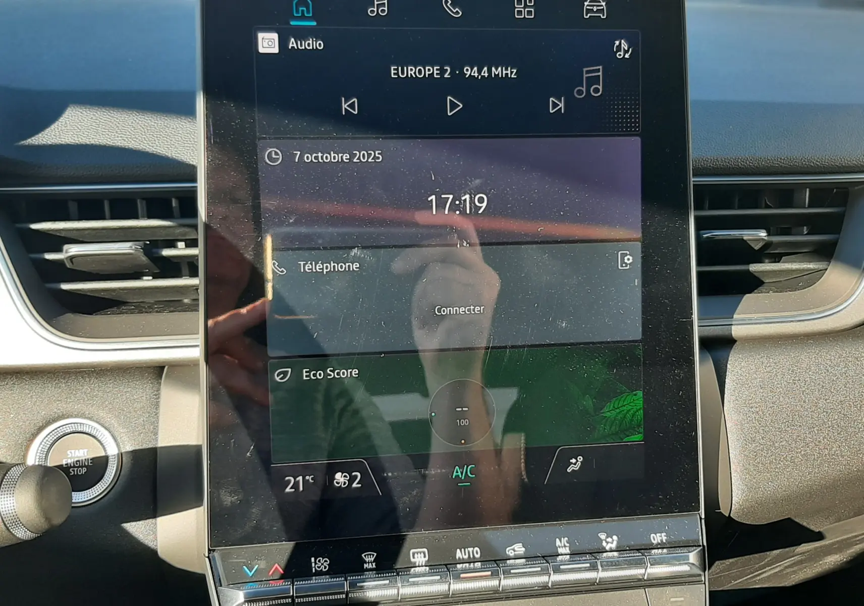 Écran tactile central du tableau de bord du Renault Captur II Ph.2 bleu Iron, affichant radio et climatisation.