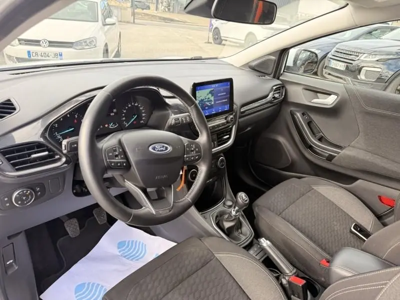 Vue intérieure côté conducteur du Ford Puma blanc 2026, avec volant multifonction, écran tactile et boîte manuelle visible.