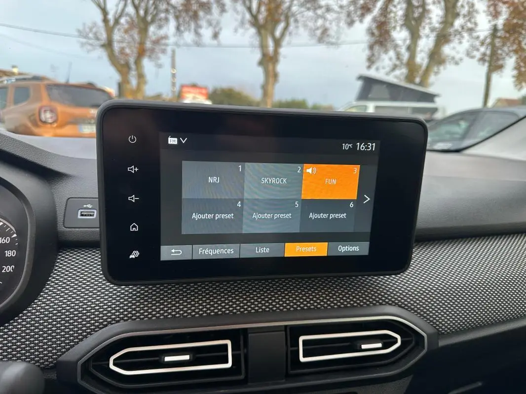 Écran tactile central de la Dacia Sandero TCe 90 2024, affichant les presets radio, intérieur noir.