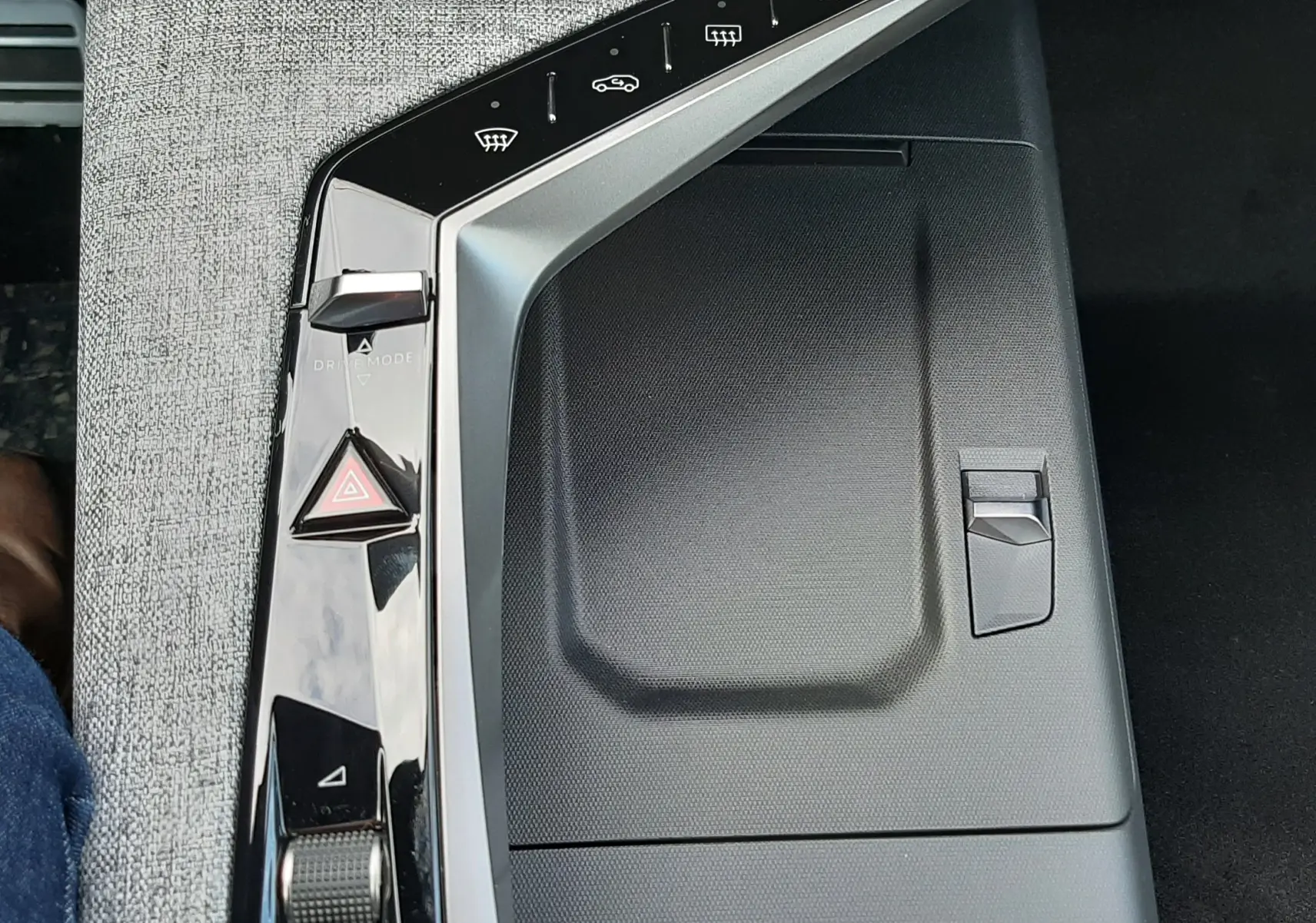 Vue rapprochée de la console centrale noire et grise du Peugeot 3008 1.2 Hybrid 2026 avec commandes tactiles et molette.