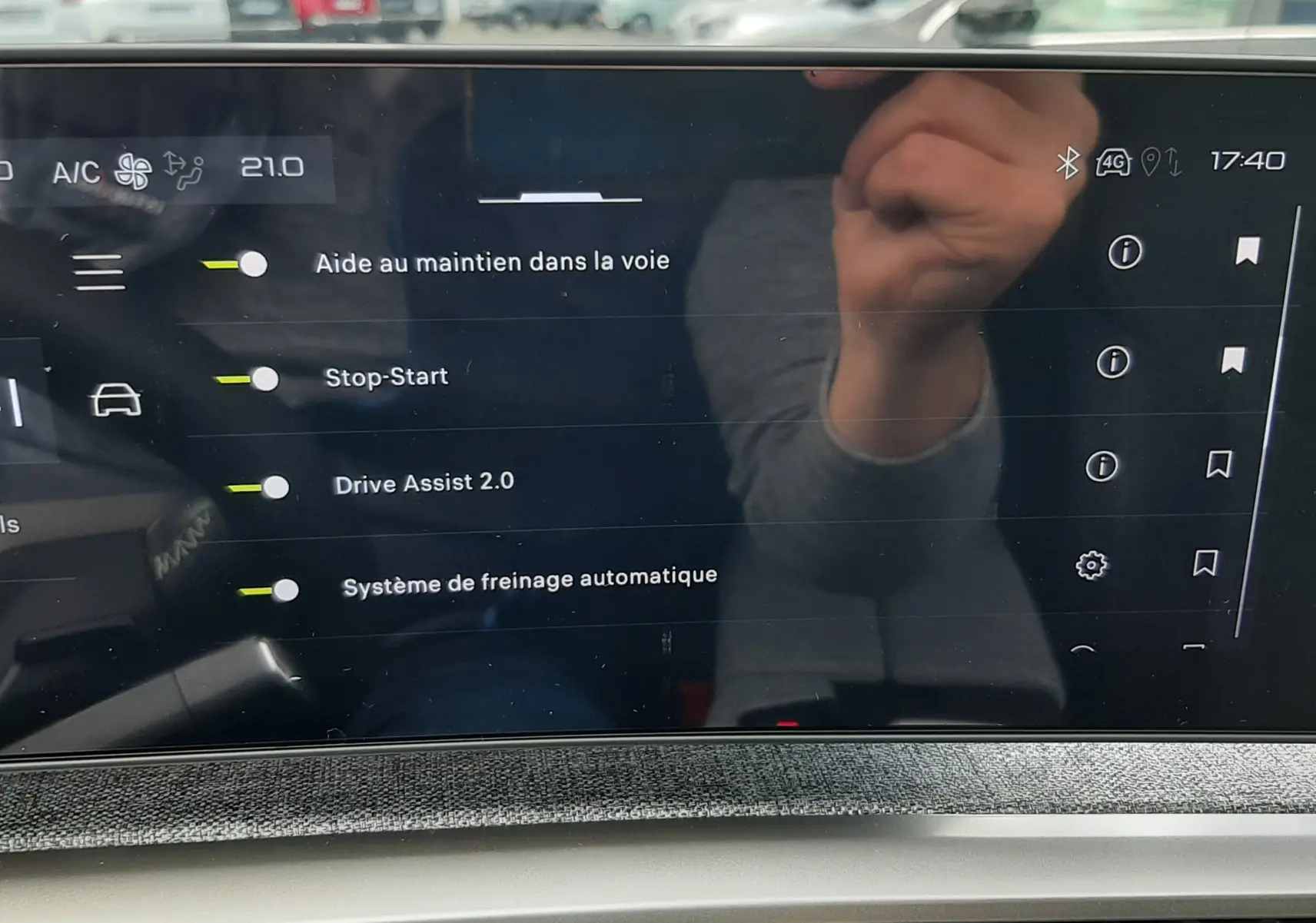 Écran tactile intérieur du Peugeot 3008 2026 affichant les options d’aide à la conduite avec reflet de la main.