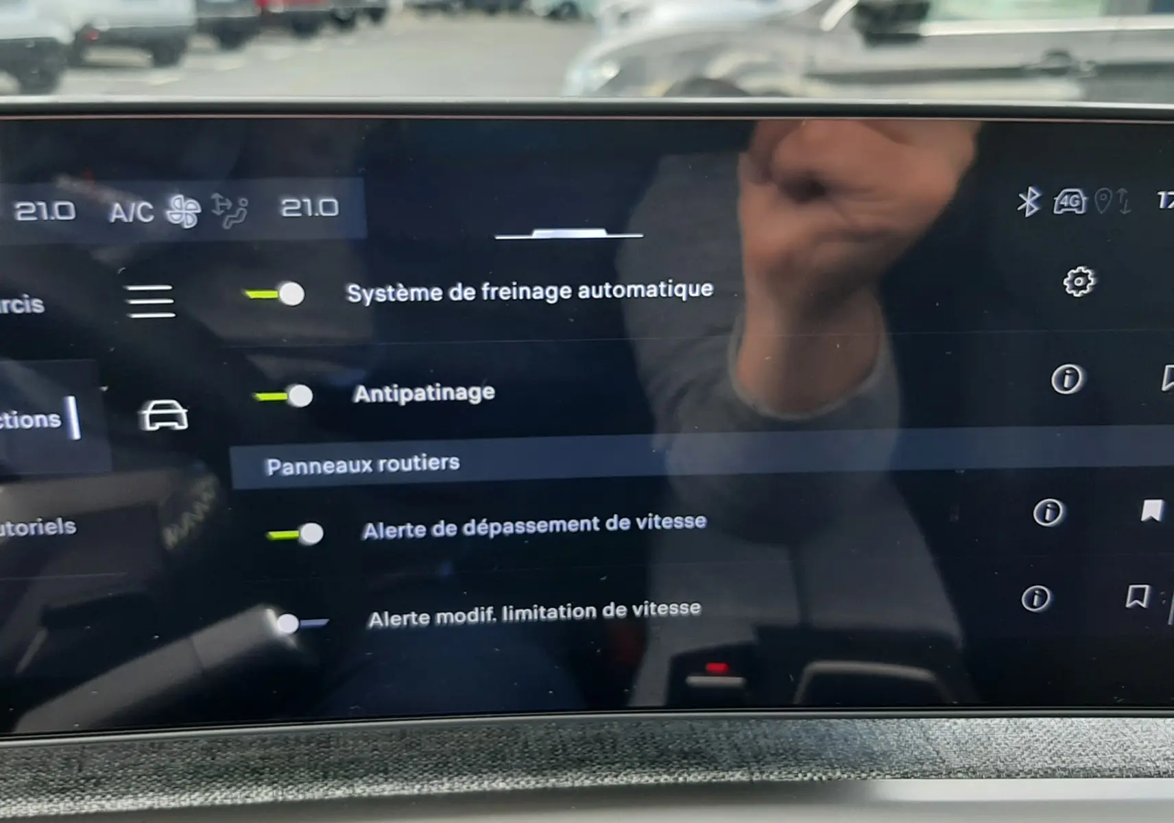 Écran tactile intérieur du Peugeot 3008 2026 montrant les réglages d’aides à la conduite, avec reflet extérieur flou.