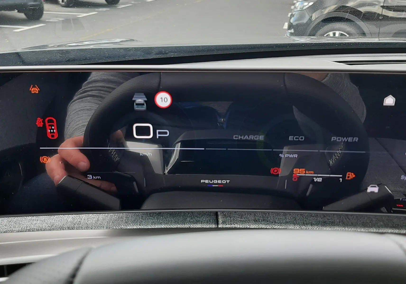 Vue intérieure du tableau de bord numérique du Peugeot 3008 hybride, affichant la vitesse et l'autonomie restante.